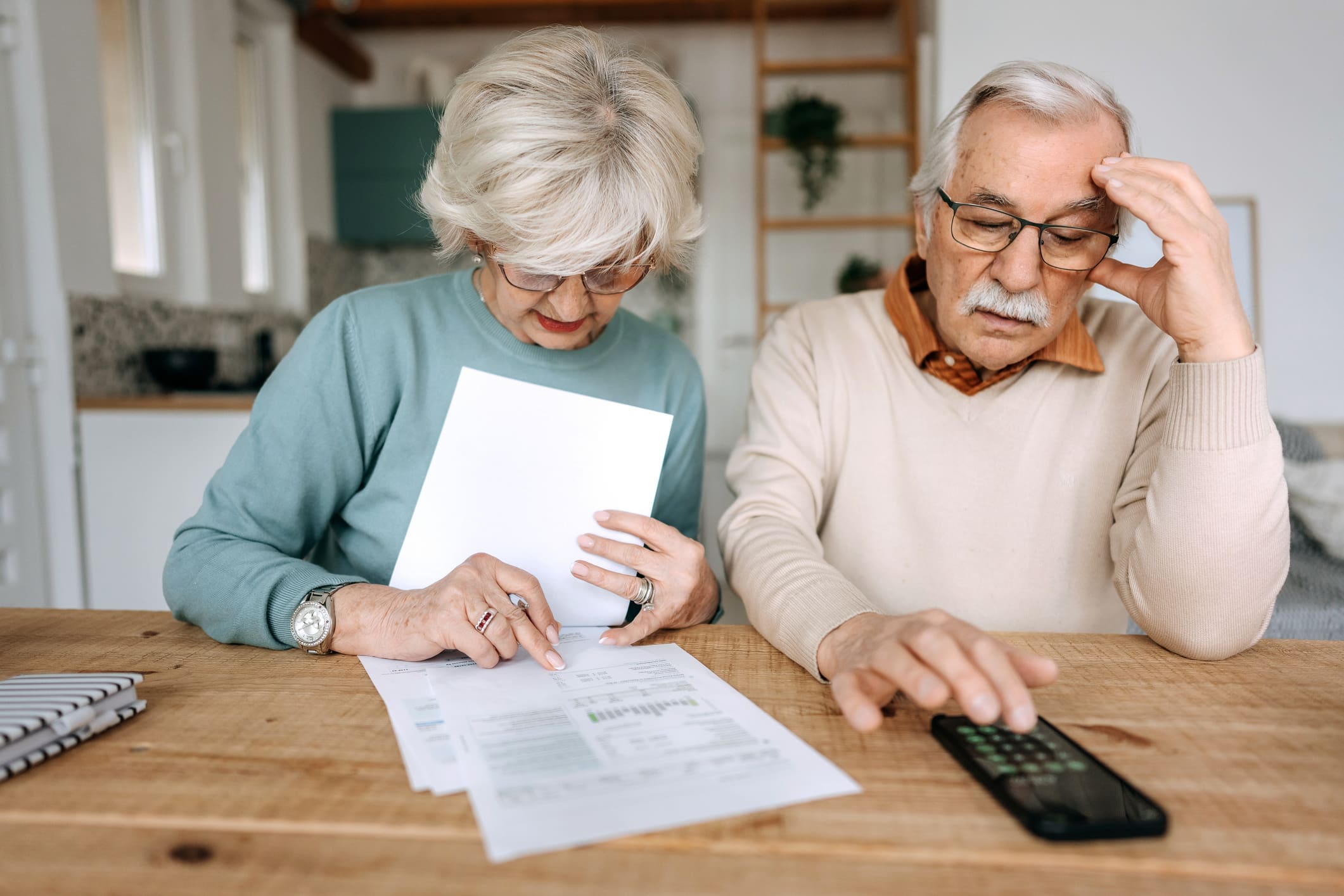 Shot of a worried mature couple managing their paperwork together at home